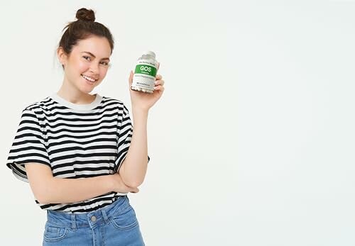 Frau hält ein Nahrungsergänzungsmittel in der Hand.